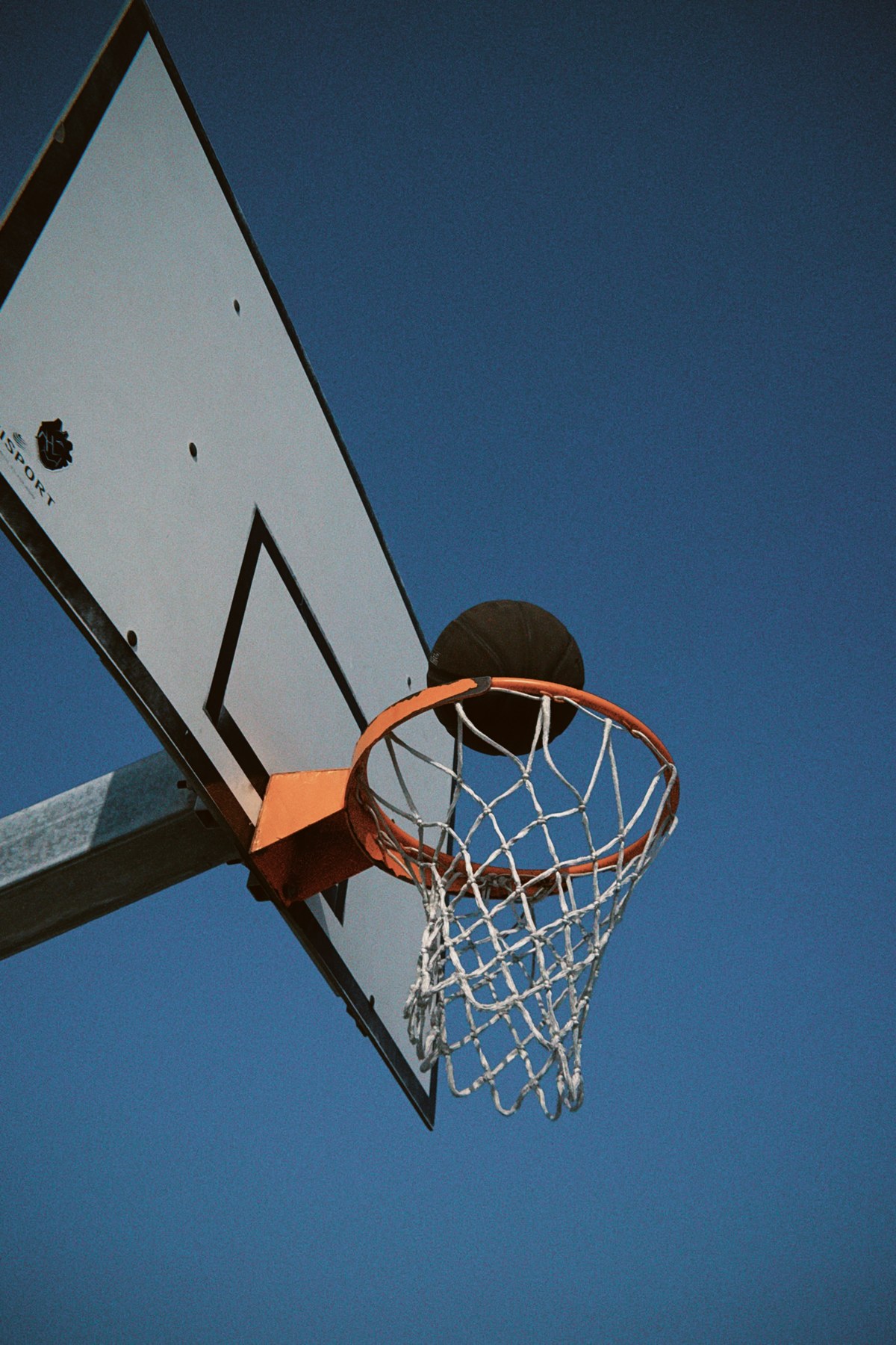 Basketball dropping through an outdoor hoop